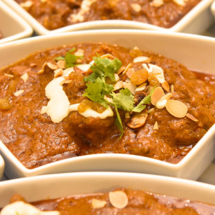 Gallery-Butter Chicken Masala carefully paired and garnished with dates, yogurt, nuts & parsley.